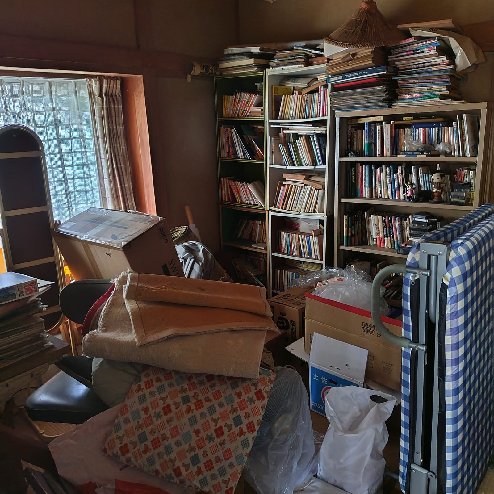 本棚や家具が残された片付け前の部屋